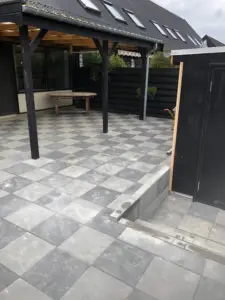 Fliseterrasse under overdækning med trappe og belægning