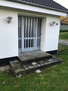 Udvendig renovering før – indgangsparti med ældre dør og belægning