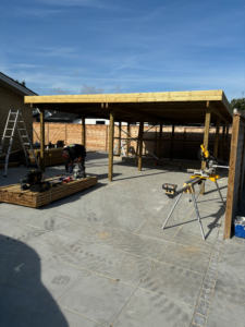 Færdig garage med træbeklædning og overdækket areal